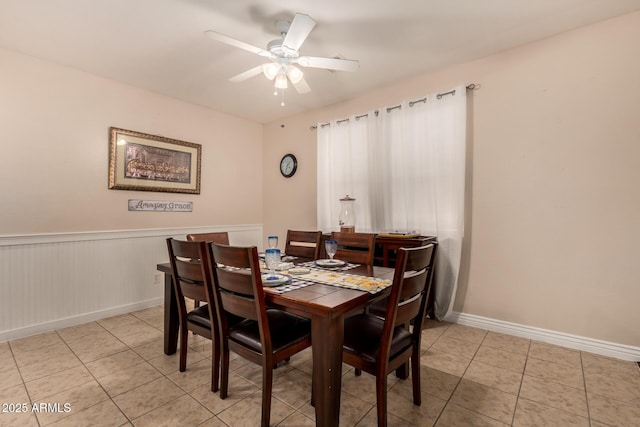 18669 W Vista Norte St, Goodyear, AZ 85338 - dining area featuring light tile patterned flooring, a ceiling fan, and a wainscoted wall