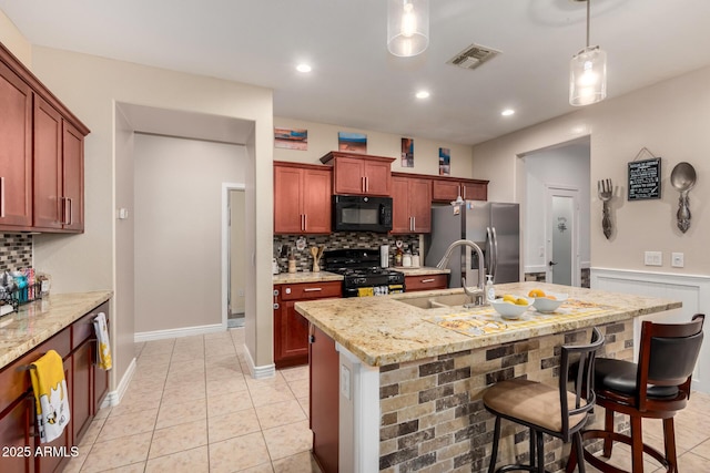 18669 W Vista Norte St, Goodyear, AZ 85338 - kitchen featuring black appliances, backsplash, decorative light fixtures, a kitchen bar, and recessed lighting