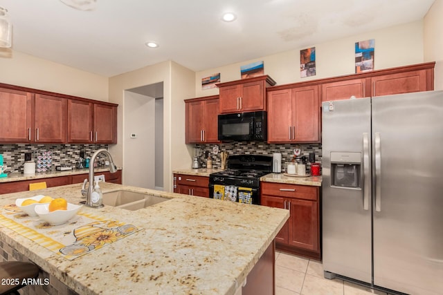 18669 W Vista Norte St, Goodyear, AZ 85338 - kitchen featuring black appliances, backsplash, light stone counters, light tile patterned floors, and a center island with sink