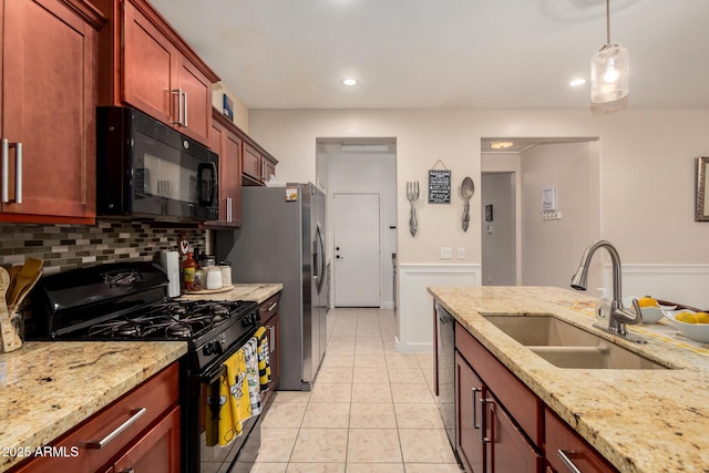 18669 W Vista Norte St, Goodyear, AZ 85338 - kitchen with black appliances, reddish brown cabinets, light tile patterned floors, backsplash, and light stone counters
