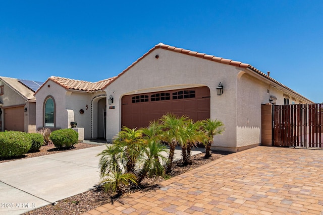 18669 W Vista Norte St, Goodyear, AZ 85338 - mediterranean / spanish-style house featuring an attached garage, stucco siding, driveway, a tiled roof, and a gate