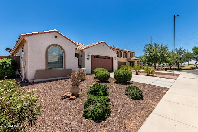 18669 W Vista Norte St, Goodyear, AZ 85338 - mediterranean / spanish-style house with a garage, a tile roof, stucco siding, and concrete driveway