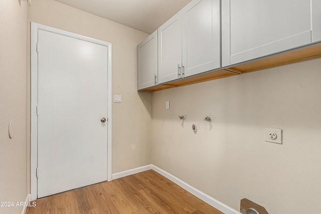 laundry area with cabinets, electric dryer hookup, and light hardwood / wood-style flooring