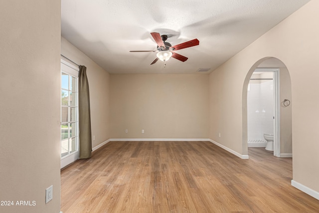 empty room with a textured ceiling, light hardwood / wood-style floors, and ceiling fan