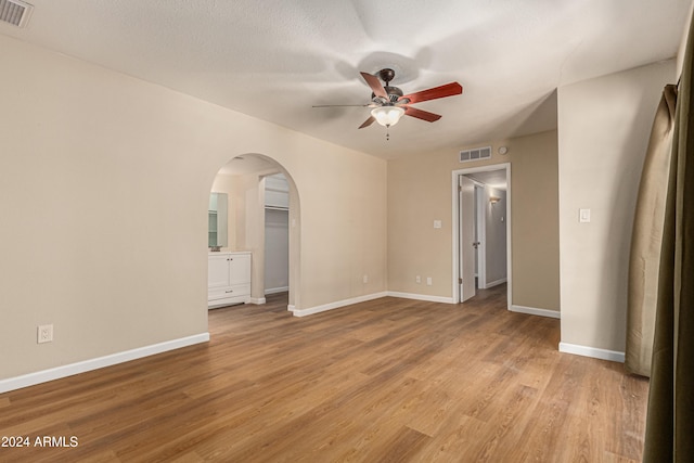 spare room with ceiling fan, light hardwood / wood-style flooring, and a textured ceiling