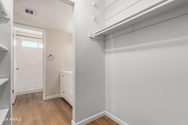 spacious closet with light hardwood / wood-style flooring