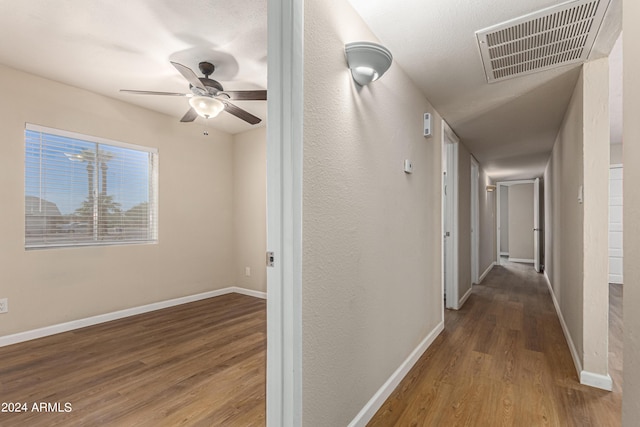 corridor with hardwood / wood-style flooring