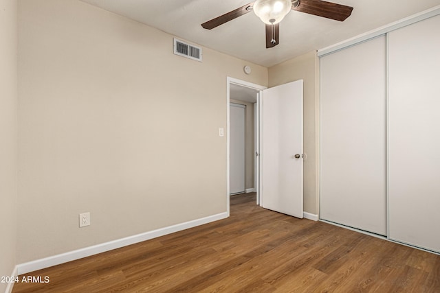 unfurnished bedroom featuring hardwood / wood-style flooring, ceiling fan, and a closet