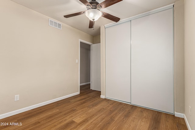 unfurnished bedroom with wood-type flooring, a closet, and ceiling fan