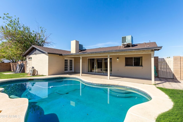 view of pool featuring french doors, a patio area, and central air condition unit