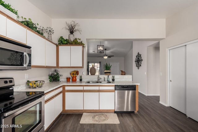 kitchen featuring light countertops, a sink, dark wood-type flooring, and stainless steel appliances