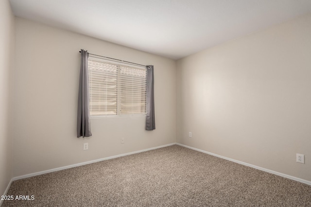 unfurnished room featuring baseboards and carpet
