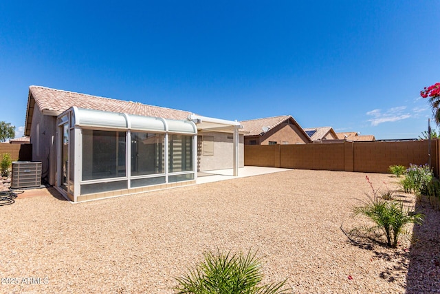 back of house featuring a fenced backyard, central AC unit, a sunroom, and a patio area