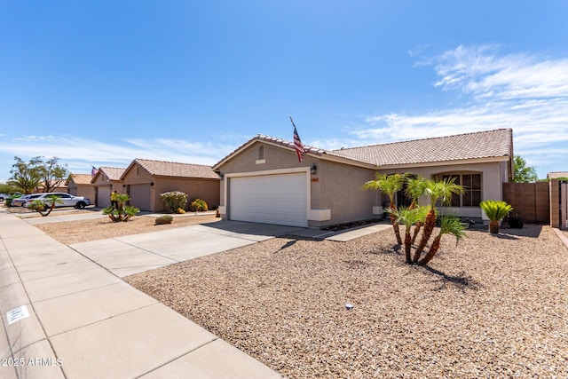 single story home featuring a tiled roof, a garage, fence, concrete driveway, and stucco siding