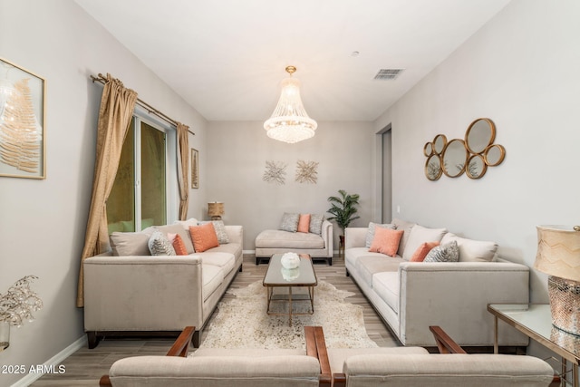 living room with an inviting chandelier and light wood-type flooring