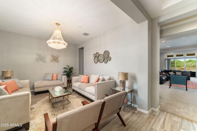 living room featuring an inviting chandelier and light hardwood / wood-style flooring