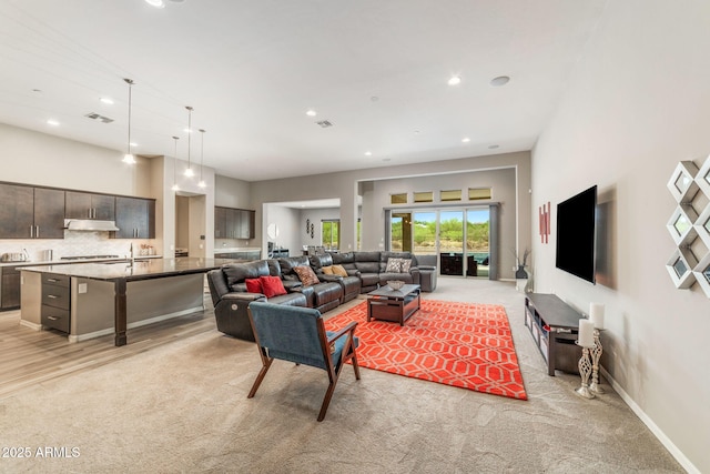 living room with a high ceiling and light colored carpet