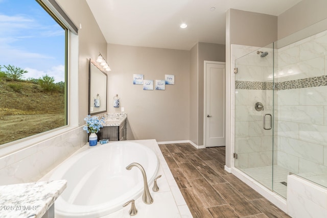 bathroom with vanity and shower with separate bathtub