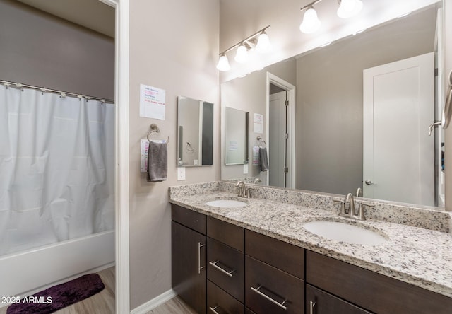 bathroom with hardwood / wood-style flooring, vanity, and shower / bathtub combination with curtain