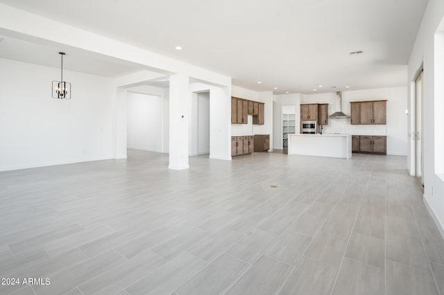 unfurnished living room with recessed lighting, visible vents, baseboards, and a chandelier