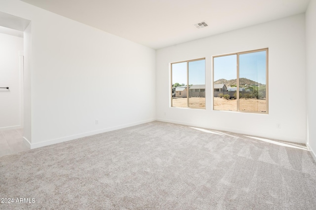 unfurnished room featuring visible vents, baseboards, and carpet