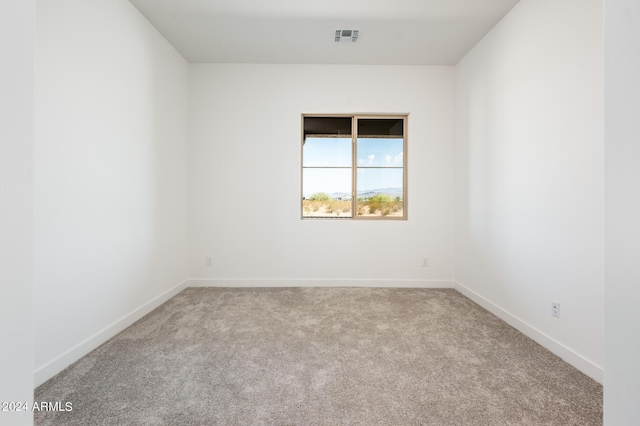 carpeted empty room featuring visible vents and baseboards