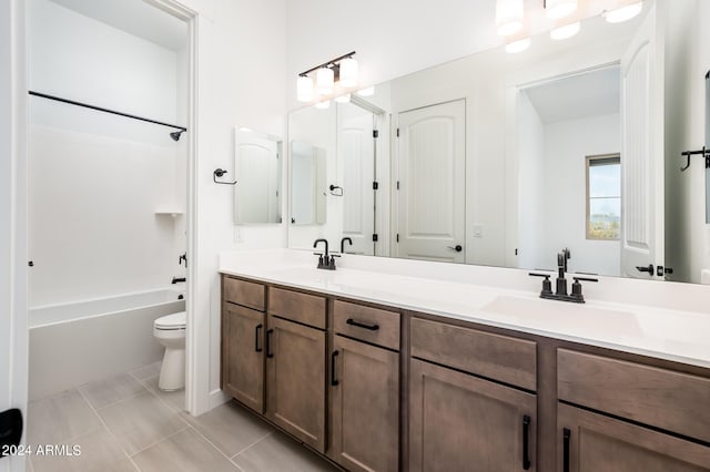 full bathroom featuring double vanity, toilet, tile patterned floors, and a sink