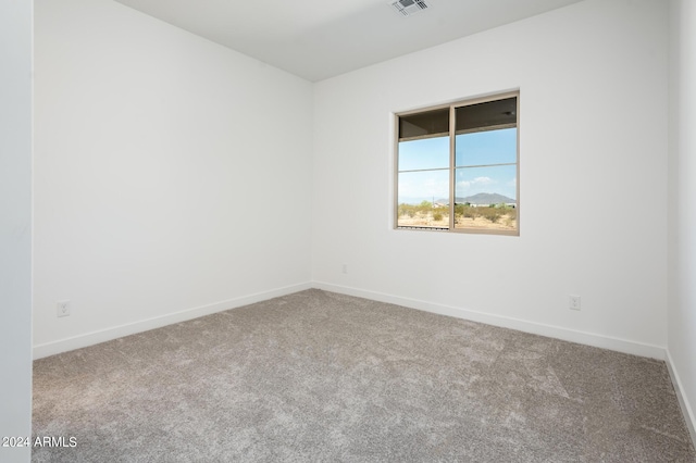 empty room featuring visible vents, baseboards, and carpet floors