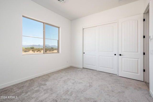 unfurnished bedroom featuring a closet, baseboards, visible vents, and carpet flooring