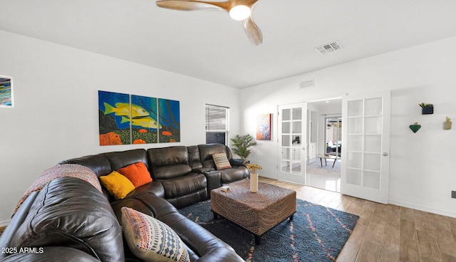 living area featuring baseboards, visible vents, wood finished floors, and french doors