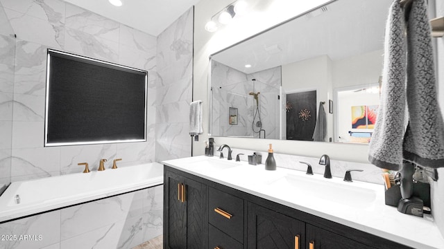 full bath featuring double vanity, a stall shower, a garden tub, and a sink