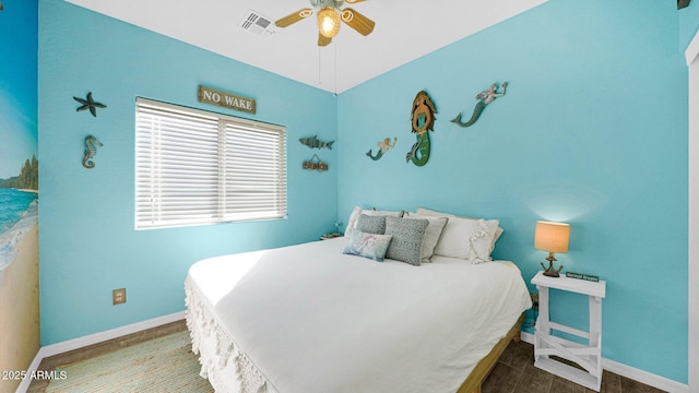 bedroom featuring a ceiling fan, baseboards, visible vents, and wood finished floors