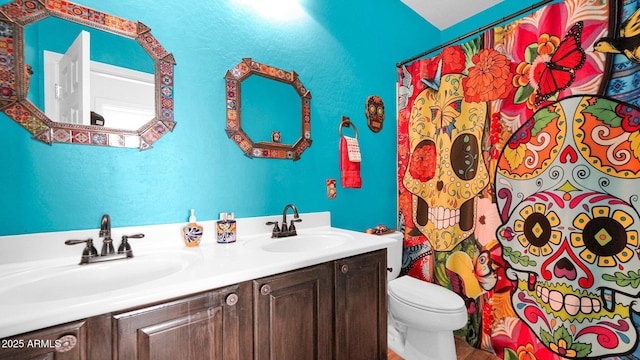 full bathroom featuring a shower with shower curtain, a sink, toilet, and double vanity