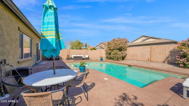 view of swimming pool featuring outdoor dining space, a patio area, a fenced backyard, and a fenced in pool