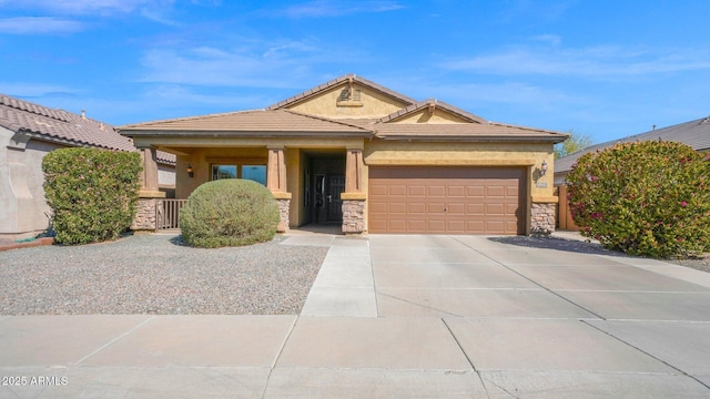 view of front of property featuring an attached garage, stone siding, driveway, and stucco siding