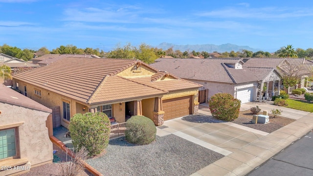 ranch-style house with a garage, a tile roof, driveway, and stucco siding