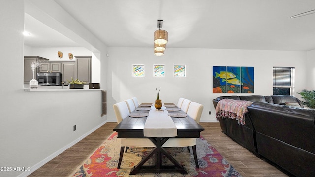 dining area featuring dark wood-type flooring and baseboards