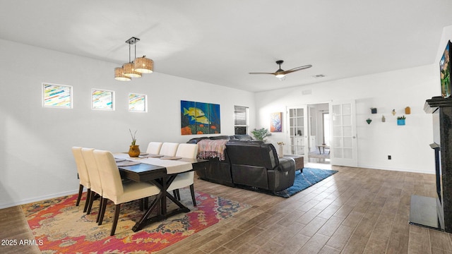 dining space with ceiling fan, baseboards, and wood finished floors