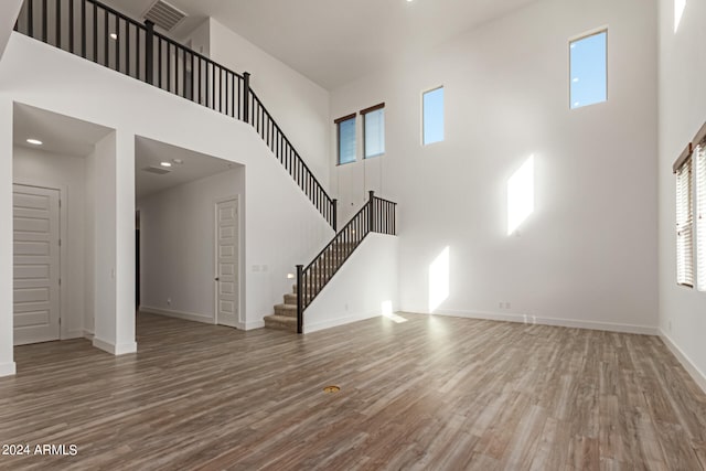 unfurnished living room featuring a healthy amount of sunlight and a high ceiling