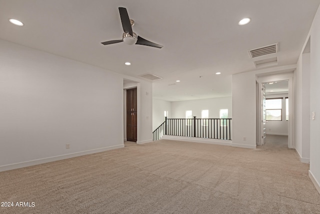 carpeted spare room featuring ceiling fan