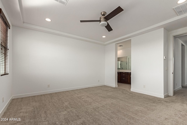 unfurnished bedroom with light carpet, connected bathroom, and ceiling fan