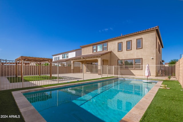 back of house featuring a pergola, a patio, a fenced in pool, and a yard