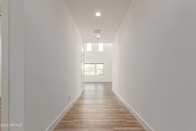 hallway with light hardwood / wood-style floors