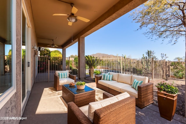 view of patio / terrace featuring a ceiling fan, a fenced backyard, a mountain view, and an outdoor living space