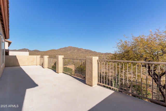 view of patio with a mountain view and fence