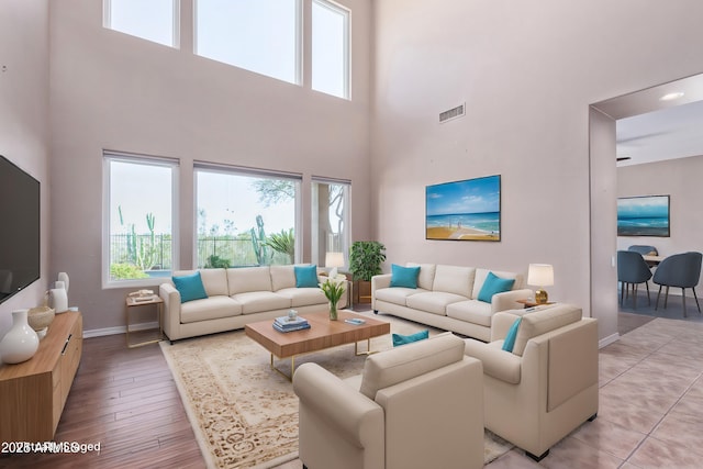 living area featuring light wood finished floors, baseboards, and visible vents