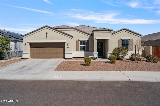 view of front of property with a tiled roof, an attached garage, driveway, and stucco siding