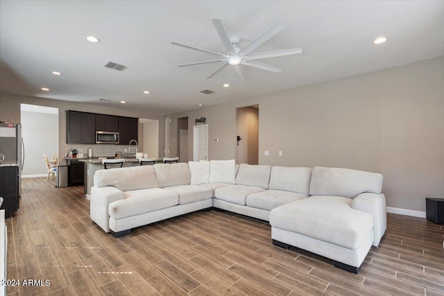 living room featuring hardwood / wood-style flooring and ceiling fan