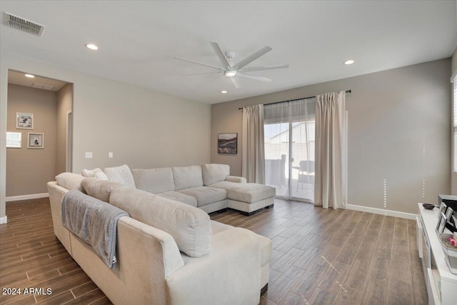 living room featuring ceiling fan and dark wood-type flooring