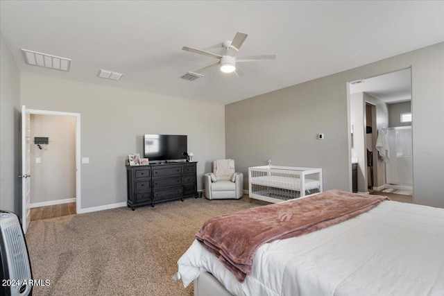 bedroom with ceiling fan, ensuite bath, and light carpet